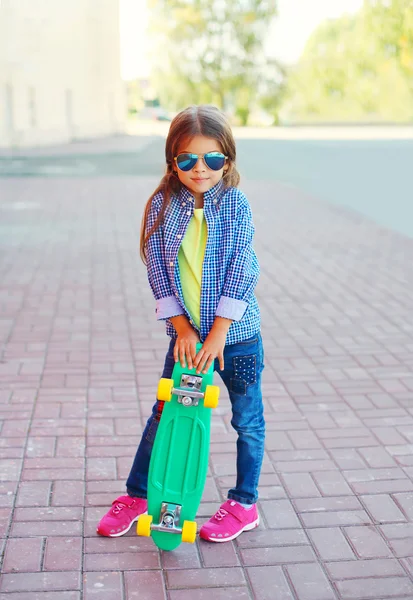 Mode lilla flicka med skateboard bär en solglasögon en — Stockfoto