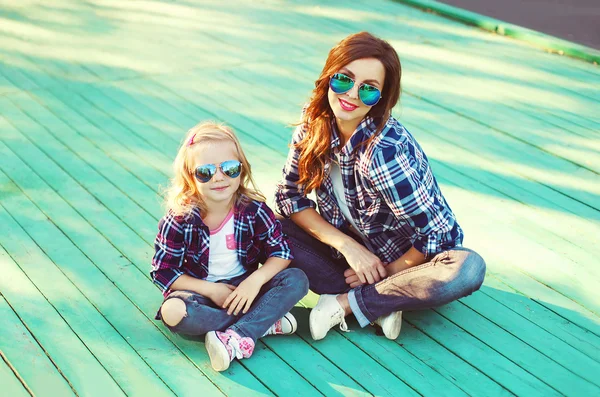 Fashion mother and child daughter wearing a sunglasses and check — Zdjęcie stockowe