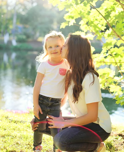 Feliz madre besando hija niño en el día de verano —  Fotos de Stock