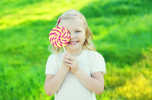 Boldog mosolygó gyermek, édes, karamell nyalóka szórakozás a su — Stock Fotó