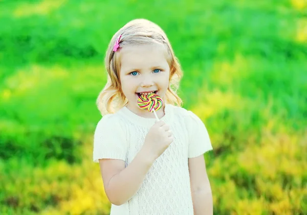 Boldog mosolygó gyermek édes karamell nyalóka, szabadban, NY — Stock Fotó