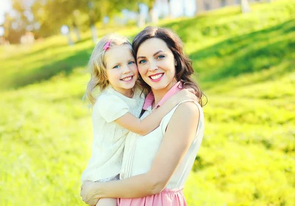 Happy smiling mother hugging child daughter in summer day — Stock Photo, Image