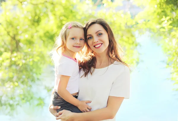 Portret gelukkig lachend moeder knuffelen kind dochter in zomerdag — Stockfoto