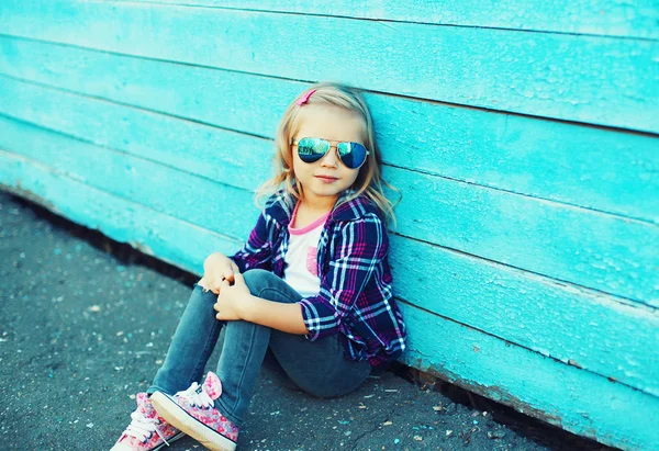 Elegante bambino che indossa un occhiali da sole e camicia a scacchi seduto i — Foto Stock