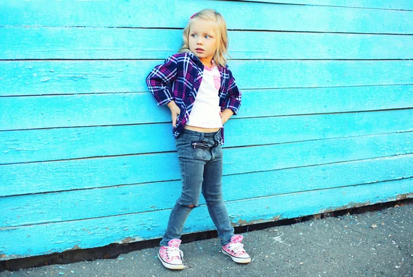 Criança menina elegante na cidade sobre fundo azul colorido — Fotografia de Stock