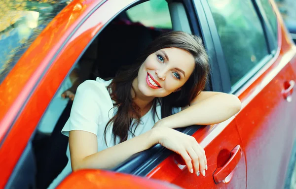 Szép mosolygó nő vezető mögött a kerék piros autó — Stock Fotó
