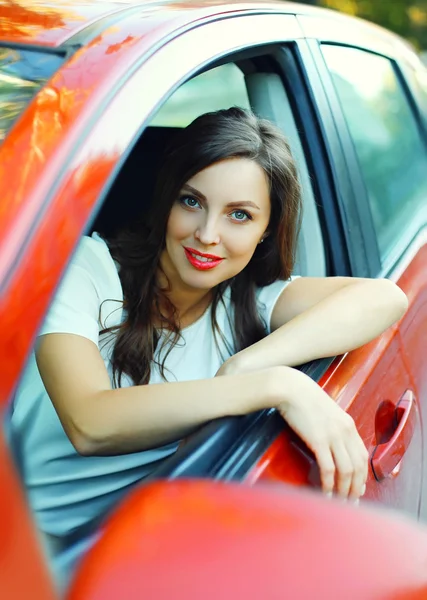 Портрет красивая женщина водитель за рулем красный автомобиль — стоковое фото