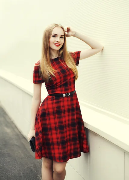 Hermosa mujer rubia sonriente con vestido a cuadros rojo en ci — Foto de Stock