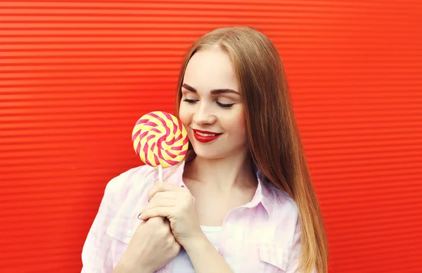 Retrato chica con dulce caramelo lollipop sobre fondo rojo — Foto de Stock