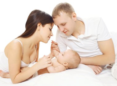 Mutlu anne ve baba ile birlikte yatakta yatarken bebek