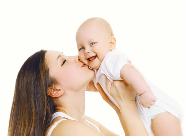 Happy mother holding on hands and kissing her cute baby over whi — Stock Photo, Image