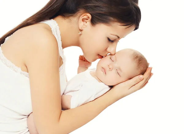 Feliz madre cariñosa besando a su bebé sosteniendo las manos sobre blanco —  Fotos de Stock