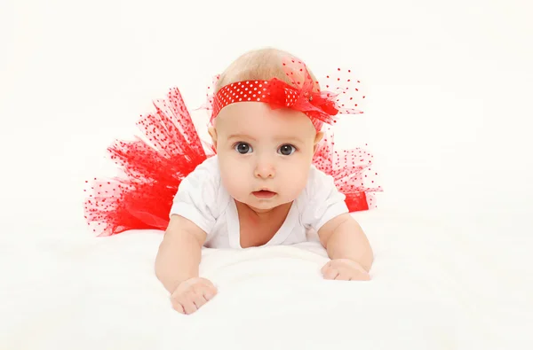 Hermosa niña pequeña acostada en falda roja en la cama —  Fotos de Stock