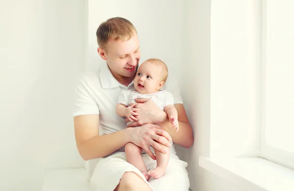 Glada leende ung pappa och baby hemma i vitt rum nära w — Stockfoto