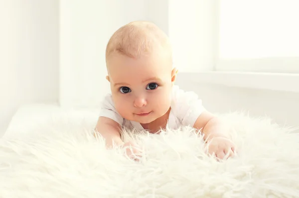 Retrato lindo bebé acostado en habitación blanca cerca de la ventana — Foto de Stock