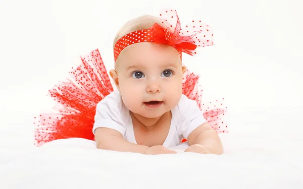 Retrato lindo bebé niña acostada en falda roja en la cama —  Fotos de Stock