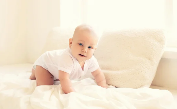 Lindo bebé se arrastra en casa en blanco habitación cerca de ventana —  Fotos de Stock