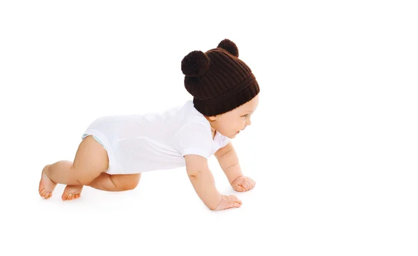 Happy cute baby in knitted brown hat crawls on white background, — Stock Photo, Image