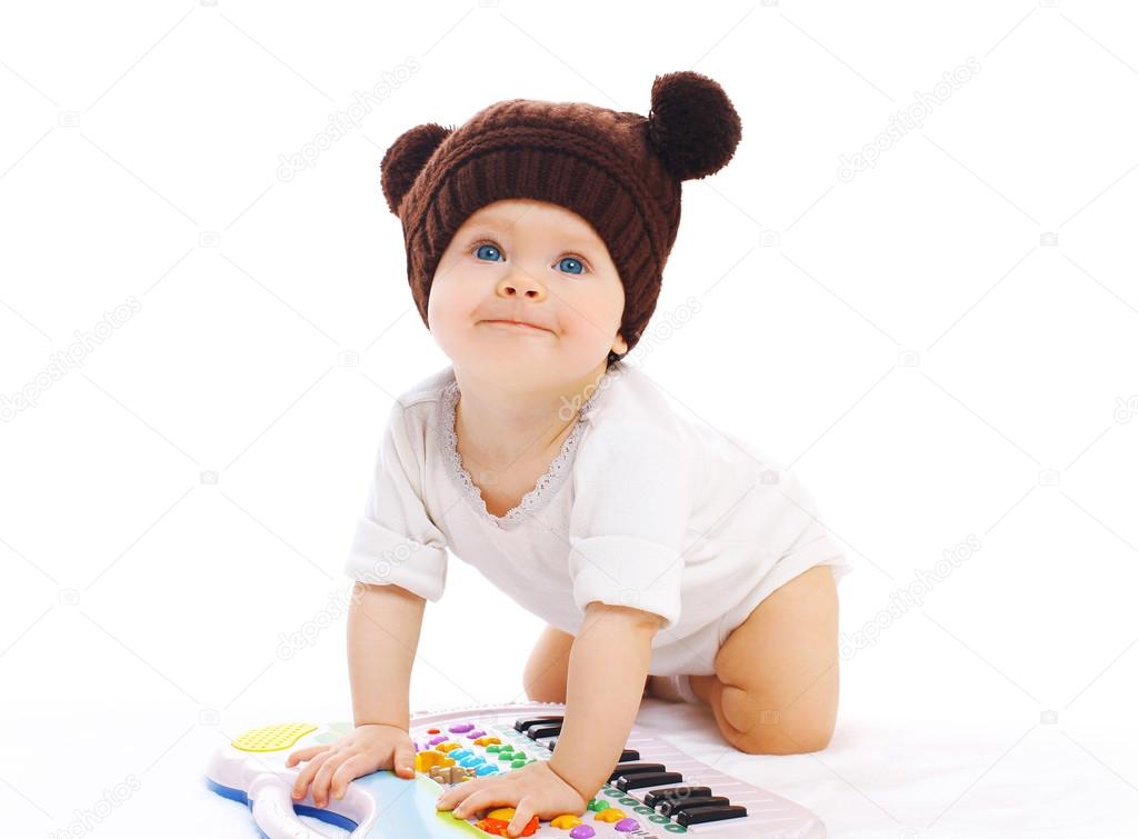 Baby playing with toy piano on a white background