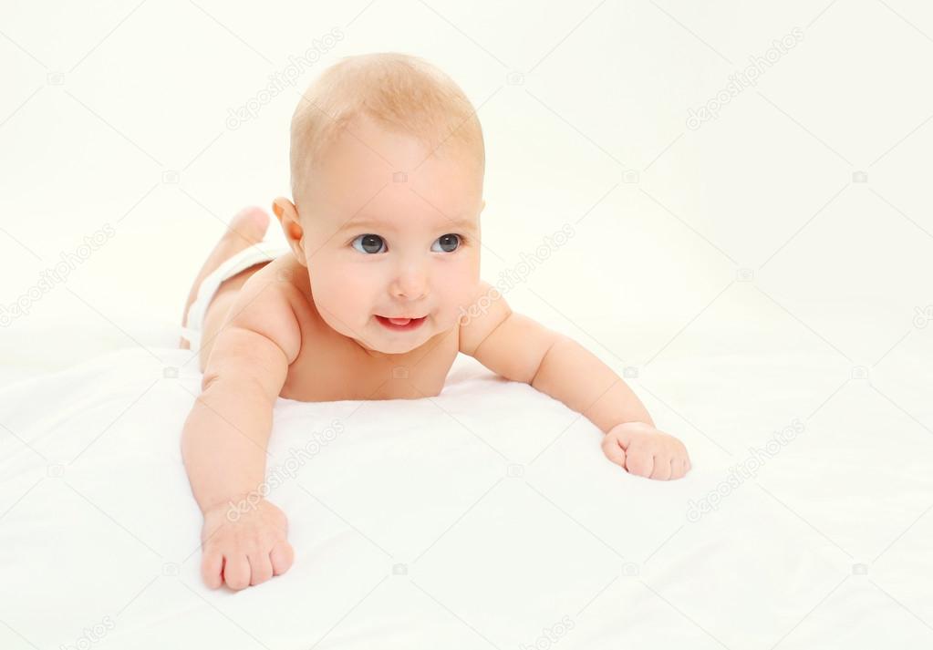Portrait of happy cute baby lying crawls on bed 