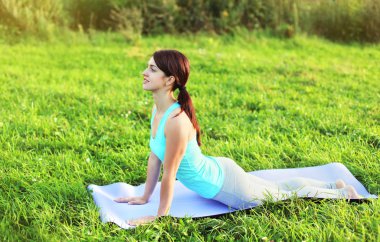 Kadının yaz Park çimenlerin üzerinde yoga egzersizleri yapması