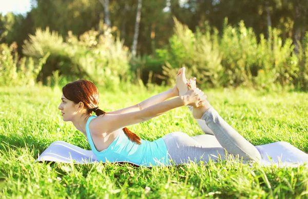 Frau macht an Sommertagen Yoga-Stretching-Übungen auf Gras — Stockfoto