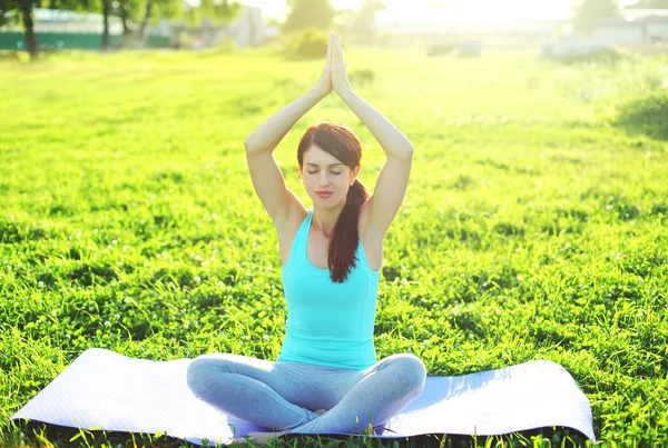 Yoga flicka mediterar sitter på gräset pose lotus i sommardag — Stockfoto