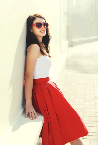 Belle femme brune portant des lunettes de soleil rouges et une jupe en c — Photo