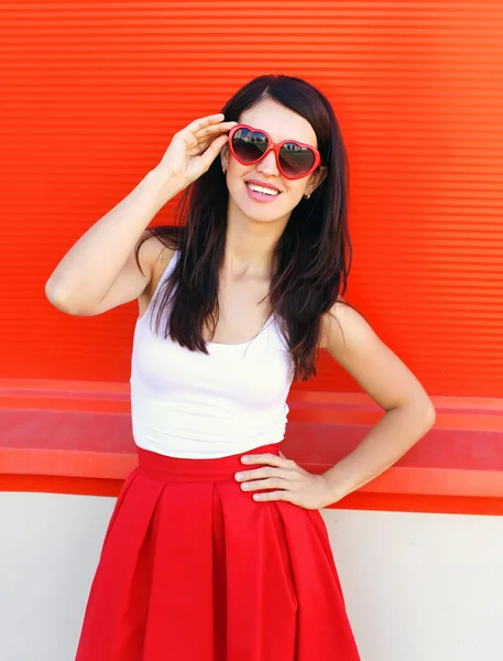 Schöne lächelnde brünette Frau mit roter Sonnenbrille und sk — Stockfoto