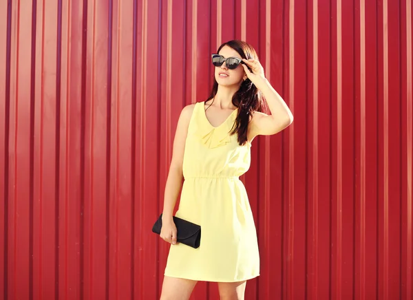 Mujer de moda con un vestido amarillo y gafas de sol con bolso —  Fotos de Stock