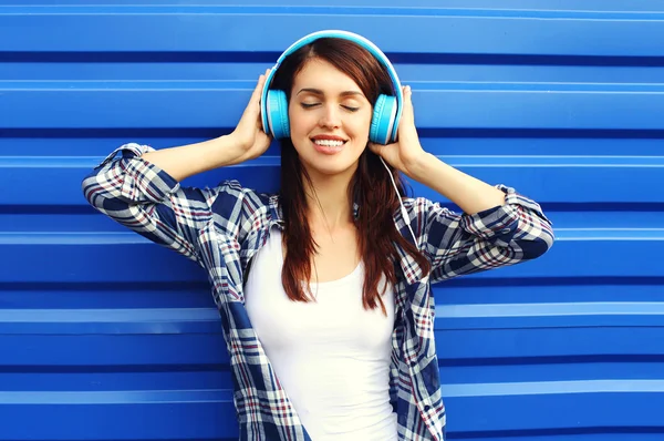 Jovem sorridente feliz ouve e gosta da música na cabeça — Fotografia de Stock