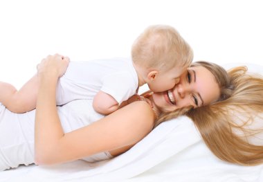 Anne ve bebek yatakta birlikte oynayan gülümseyen mutlu 