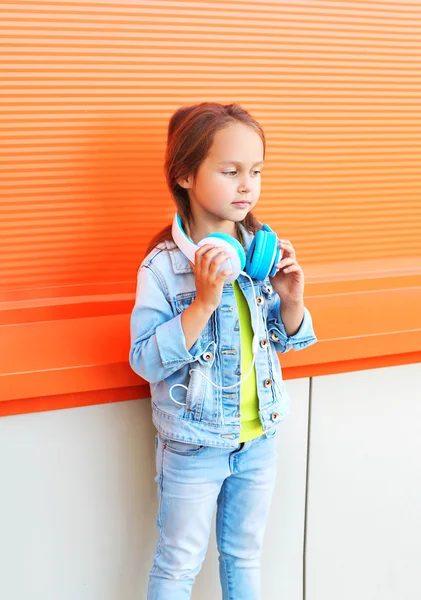Vackra lilla tjej barn bär jeans kläder med headpho — Stockfoto