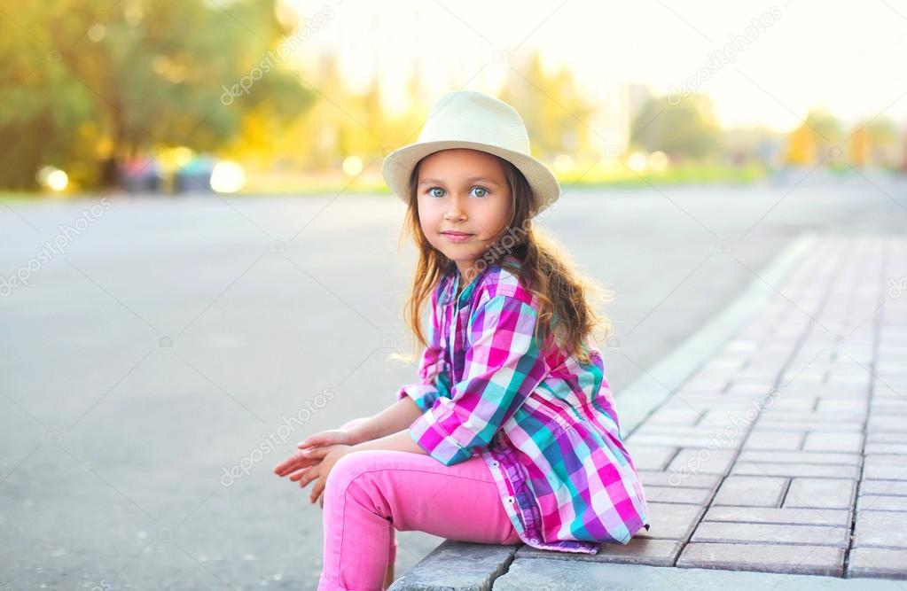 Beautiful little girl child wearing a checkered pink shirt and h