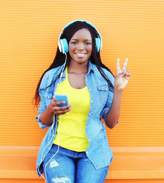 Happy smiling african woman with headphones enjoying listens to — Φωτογραφία Αρχείου