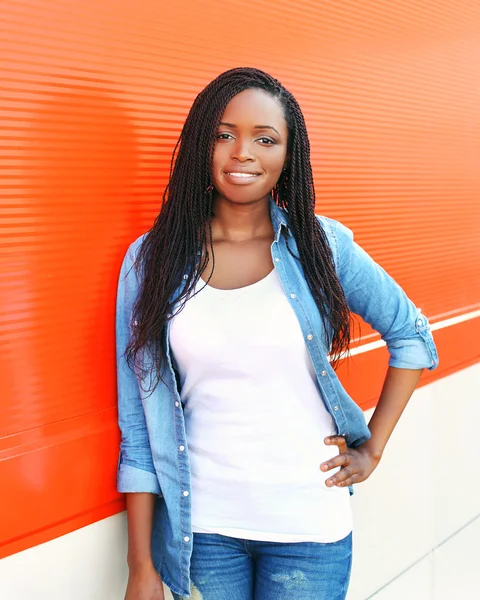 Портрет красивої молодої африканки на червоному тлі — стокове фото