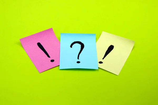 Question mark and exclamation mark stickers on light green background. Search concept.