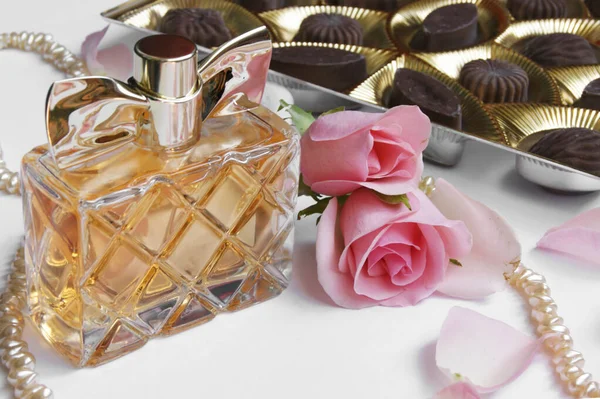 Butelka Perfum Różą Płatkami Róż Perłami Czekoladkami Jasnym Tle Perfumeria — Zdjęcie stockowe