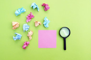 Yeşil arka planda büyüteç ve boş çıkartma var. Boşluğu kopyala.