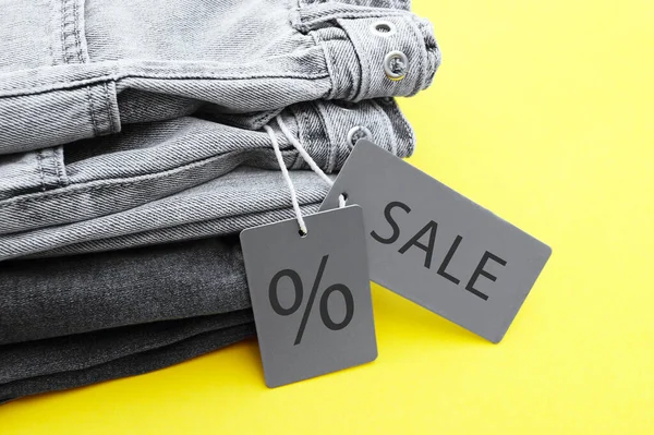 黑色牛仔裤的细节 灰色标签和黄色背景的文字销售 购物和打折的概念 黑色星期五 — 图库照片