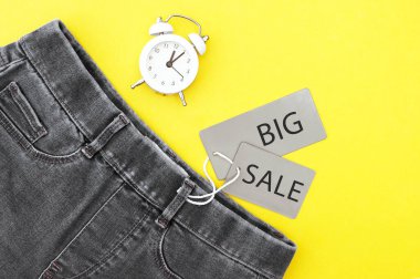 Düz yatış, siyah kot, gri etiketler ve sarı arka planda büyük indirim. Alışveriş ve indirim konsepti. Kara Cuma.