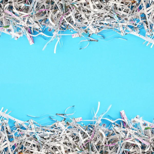 Shredded paper on light blue background. Selective focus image.