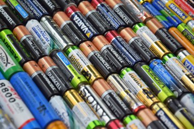 Kharkiv, Ukrayna - 20 Temmuz 2025: Kullanılmış AA bataryalar ve çevresel ve toprak toksik bataryaların yeşil arka planda düzgün bir şekilde imha edilmesi.