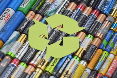 Kharkiv, Ukrayna - 20 Temmuz 2025: Kullanılmış AA bataryalar ve çevresel ve toprak toksik bataryaların yeşil arka planda düzgün bir şekilde imha edilmesi.