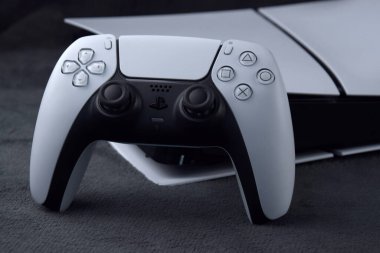 Kharkiv, Ukrayna - 10 Temmuz 2025: Beyaz Sony PlayStation 5 ve karanlık masa üzerindeki denetleyici.