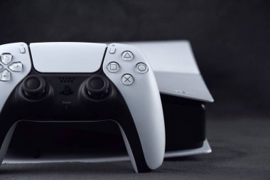 Kharkiv, Ukrayna - 10 Temmuz 2025: Beyaz Sony PlayStation 5 ve karanlık masa üzerindeki denetleyici.