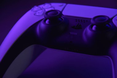 Kharkiv, Ukrayna - 10 Temmuz 2025: Beyaz Sony PlayStation 5 ve karanlık masa üzerindeki denetleyici.