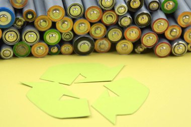 Kullanılmış AA bataryalar ve çevresel atık ve yeşil arka planda toprak toksik bataryalar. Zararlı ve geri dönüşümlü nesnelerin işlenmesi kavramı.