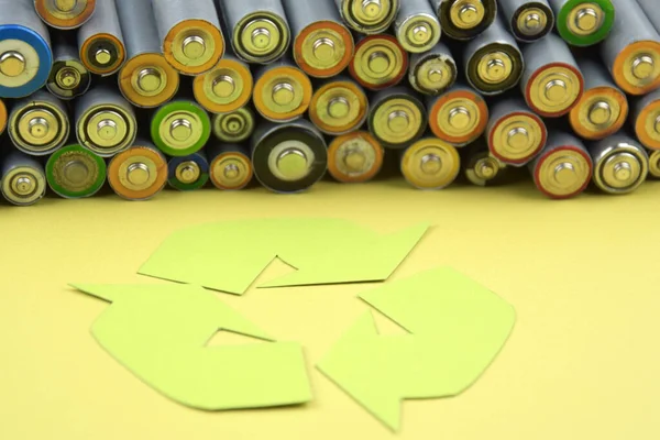 Kullanılmış AA bataryalar ve çevresel atık ve yeşil arka planda toprak toksik bataryalar. Zararlı ve geri dönüşümlü nesnelerin işlenmesi kavramı.