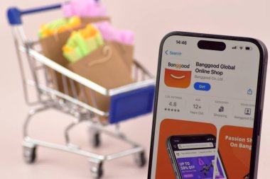 KHARKOV, UKRAINE - 18 Ağustos 2024: Akıllı telefonlu alışveriş arabası ekranda Banggood uygulaması açık.